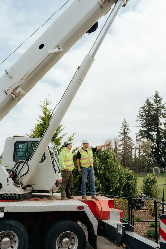 Westmore crew member pointing up toward a crane boom during lift setup