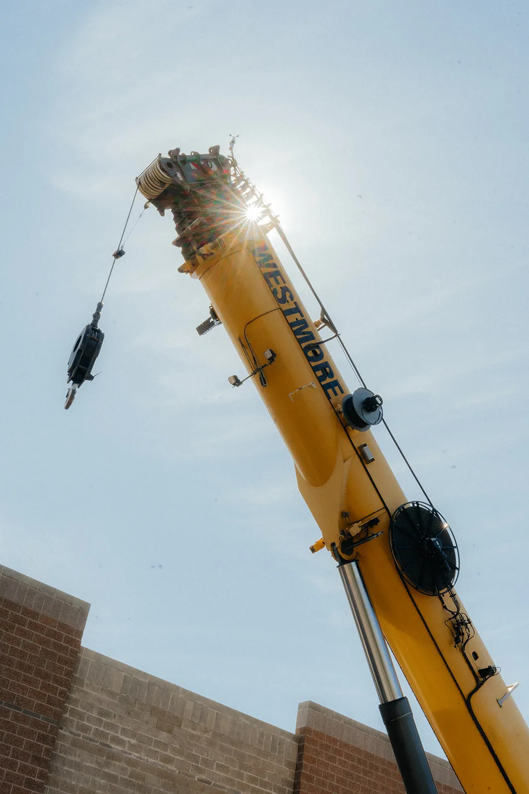 Westmore crane boom raised high against the sky with WESTMORE lettering on the boom